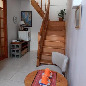 uma sala de estar com uma mesa e uma escada em Habitación con Baño Privado - Frigo bar y sector para desayunar - Sin cocina em Ushuaia