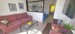 ein Wohnzimmer mit einem roten Sofa und einem Tisch in der Unterkunft Ferienwohnung Aurora in Giniginámar