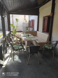 un patio con tavolo e sedie sul balcone. di Vila Maria a Buşteni
