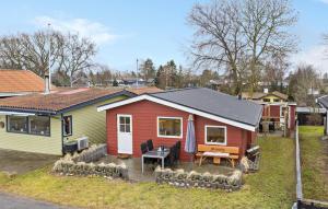 ein kleines rotes und gelbes Haus mit einem Picknicktisch in der Unterkunft Gorgeous Home In Otterup With Wifi in Otterup