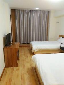 延吉的住宿－鑫明時尚賓館，酒店客房设有两张床和电视。