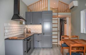 a kitchen with gray cabinets and a wooden table at Gorgeous Home In Sturkö With Kitchen in Sturkö