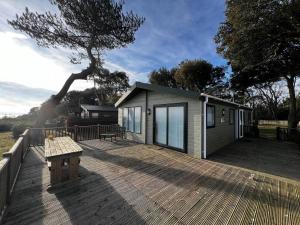 a tiny house with a bench on a deck at Luxury Lodge With Full Sea Views At Azure Seas In Suffolk Ref 32105og in Lowestoft