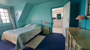 a blue bedroom with a bed and a bathroom at Le Beauvais, son gîte, ses chambres en Bourgogne in Saint-Saulge