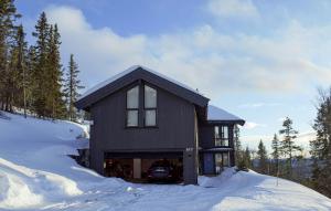 una casa negra en la nieve con nieve alrededor en Amazing Home In Eggedal With Wifi en Eggedal