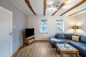 a living room with a blue couch and a tv at Ferienwohnung Haseltal in Rotenburg an der Fulda