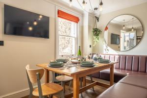 a dining room with a wooden table and a mirror at Castle House 4 in Wells next the Sea