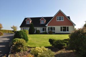 a house with a green yard with bushes at Nymphsfield House in Cong