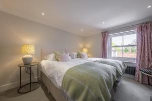 a bedroom with two beds and a window at Old Mill House 6 in Brancaster