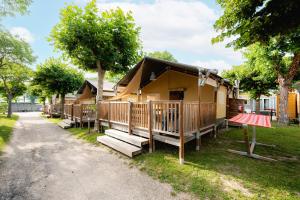 a house with a porch and benches in front of it at Glamping Virton in Virton
