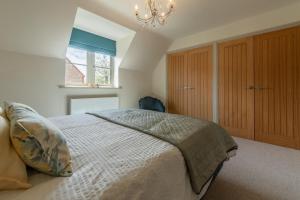 Un dormitorio con una cama grande y una lámpara de araña. en Long Meadow 2, en Great Bircham