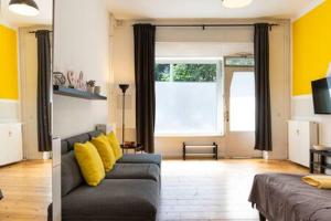 a living room with a couch and yellow pillows at Cosy Apartment plus Self Checkin plus free Street parking in Berlin