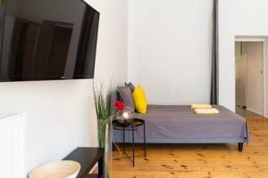 - une chambre avec un lit doté de draps violets et d'oreillers jaunes dans l'établissement Cosy Apartment plus Self Checkin plus free Street parking, à Berlin