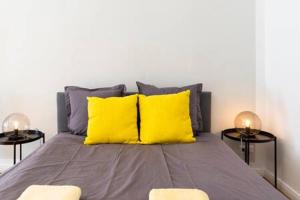- un lit avec 2 oreillers jaunes et 2 tables dans l'établissement Cosy Apartment plus Self Checkin plus free Street parking, à Berlin 6 autres photos