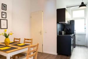 une cuisine avec une table à manger et une cuisine avec une table et des chaises dans l'établissement Cosy Apartment plus Self Checkin plus free Street parking, à Berlin
