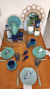 una mesa de madera con platos y utensilios. en Pipa Céu Azul, en Pipa