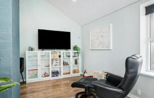 a living room with a black chair and a flat screen tv at Lovely Home In Bogense With Wifi in Bogense