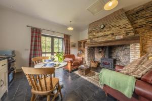 a living room with a brick wall and a fireplace at Pettingalls Farm Cottage in Great Ellingham