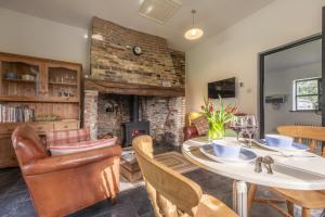 a living room with a table and a fireplace at Pettingalls Farm Cottage in Great Ellingham