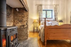 um quarto com uma cama e uma lareira em Pettingalls Farm Cottage em Great Ellingham