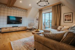 a living room with a couch and a tv at VisitZakopane - Premium Best View&Spa Apartment in Zakopane