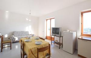 ein Wohnzimmer mit einem Tisch und einem TV in der Unterkunft 2 Bedroom Gorgeous Apartment In Badolato Marina in Badolato