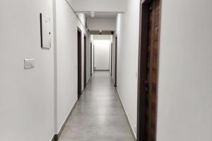 an empty corridor with white walls and a long hallway at FabHotel KSP Kings Inn in Bangalore