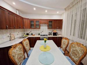 uma cozinha com mesa e cadeiras e um balcão em Просторная 3 комнатная квартира em Taraz