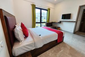 a bedroom with a large bed with red and white pillows at FabHotel KSP Kings Inn in Bangalore