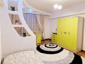a room with a yellow cabinet and a rug at Просторная 3 комнатная квартира in Taraz