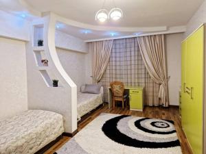 um quarto com 2 camas, uma secretária e uma mesa em Просторная 3 комнатная квартира em Taraz
