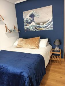 um quarto com uma cama com uma pintura de uma onda em Alicante airport and beach em El Altet