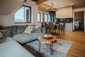 a living room with a couch and a table at VisitZakopane - Premium Best View&Spa Apartment in Zakopane