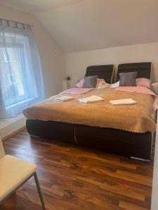 een groot bed in een slaapkamer met een houten vloer bij Dubrovnik1 in Mönchengladbach