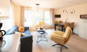 - un salon avec un canapé bleu et une table dans l'établissement Appartementen Zuiderstrand Zoutelande, à Zoutelande