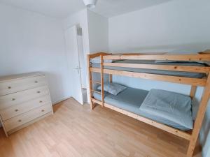 ヴァロン・ポン・ダルクにあるLa Cour des Miraclesの二段ベッド2台、ドレッサーが備わる二段ベッドルームです。