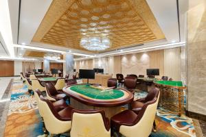 un casino con mesa de póquer y sillas en Grand Pailin Casino & Resort, 