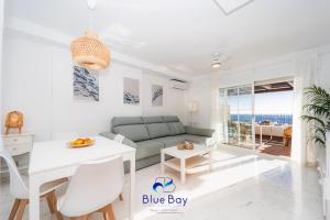 Una sala de estar blanca con un sofá y una mesa. en Penthouse La Roca, en La Herradura