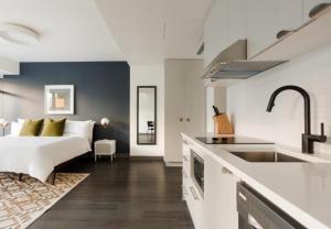 cocina y dormitorio con cama y lavamanos en Resort Inn Centrum en Szczecin