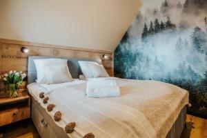 a bedroom with a large bed with a painting on the wall at VisitZakopane - Premium Best View&Spa Apartment in Zakopane