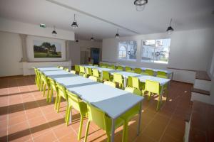 a row of tables and yellow chairs in a room at HI Évora – Pousada de Juventude in Évora