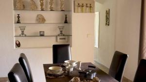 una sala da pranzo con tavolo, sedie nere, tavolo e sedie a sdraio di Résidence U Pirellu a Porto Vecchio