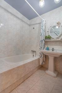 a bathroom with a tub and a sink at YourHouse A Casa Dos Cregos in Fonteita