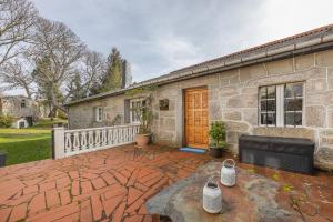 a stone house with a brick patio and a building at YourHouse A Casa Dos Cregos in Fonteita