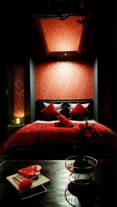 a bedroom with a red bed with a red head board at O' Plaisirs Interdits - Loveroom in Caen +14 photos