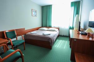 una camera d'albergo con letto e scrivania di Hotel Krakowiak a Cracovia