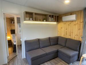 una sala de estar con sofá en una habitación pequeña en Holiday Home Tinyhaus am See by Interhome, en Wemding