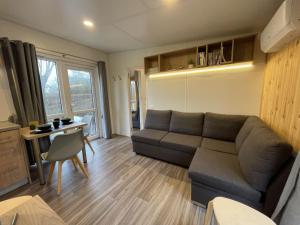 uma sala de estar com um sofá e uma mesa em Holiday Home Tinyhaus am See by Interhome em Wemding