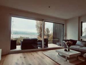 a living room with a couch and a table at Wohnung am Zürichsee mit Seeblick und Parkplatz in Horgen