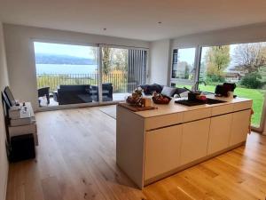 una sala de estar con una gran cocina con una gran ventana en Wohnung am Zürichsee mit Seeblick und Parkplatz, en Horgen